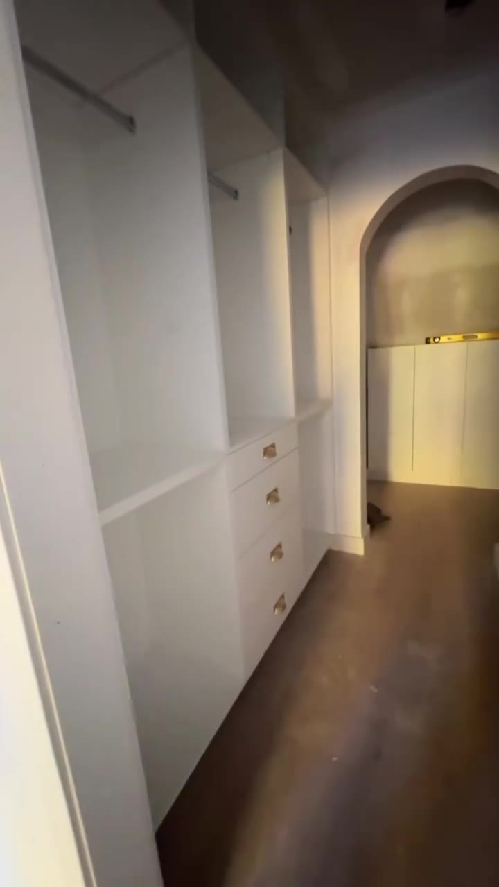 White built-in millwork beside an arched opening