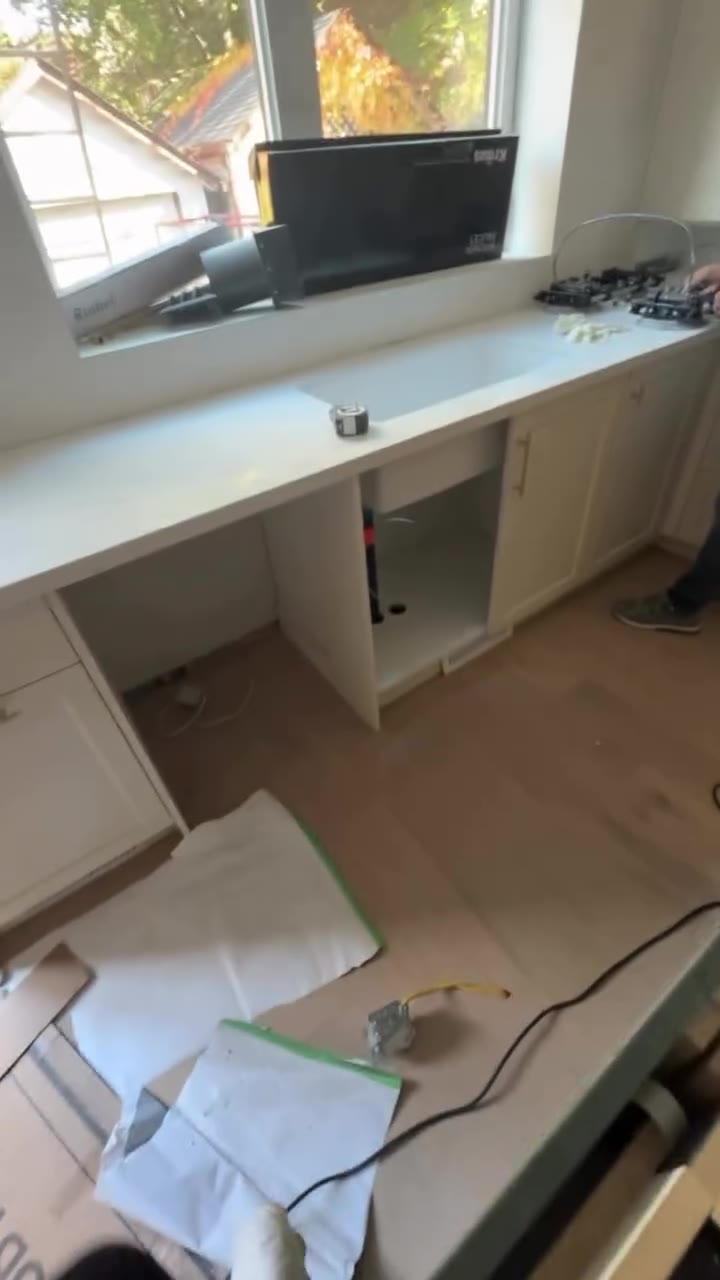 White sink and countertop beneath a kitchen window