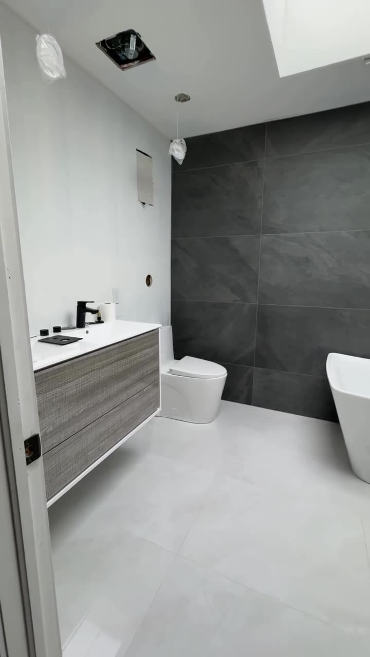 Finished bathroom with floating vanity and dark tile
