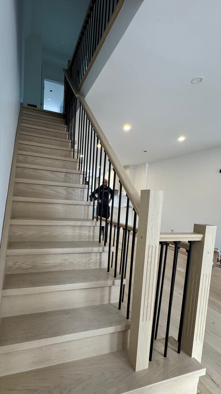 Finished oak staircase with black iron balusters
